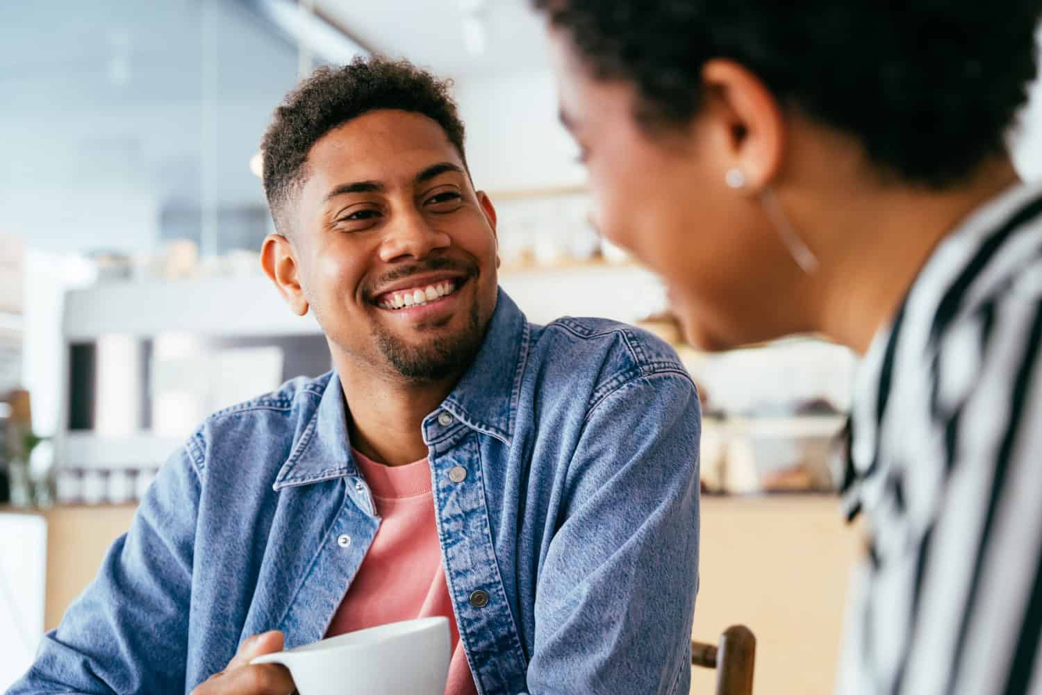 Beautiful young mixed race couple bonding and sitting in a bar cafeteria