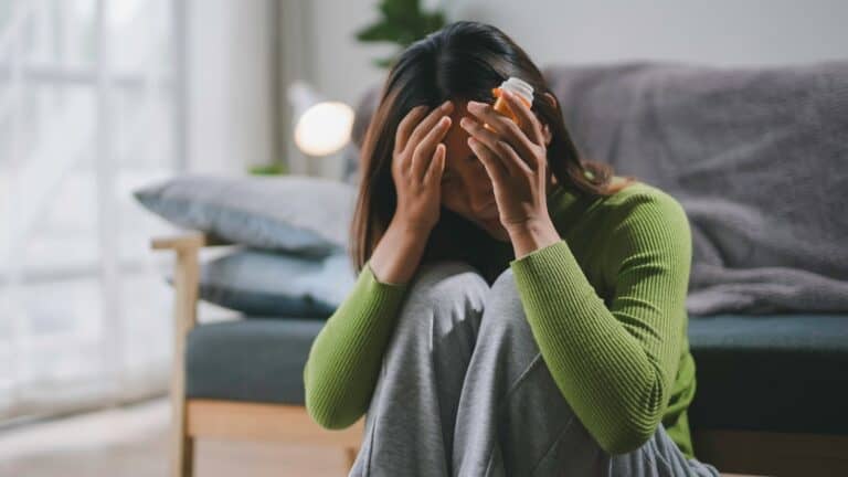 Distressed Woman Holding Medication Bottle in Home