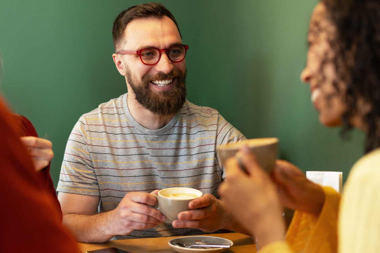 Friends enjoying cappuccino and talking in cafe