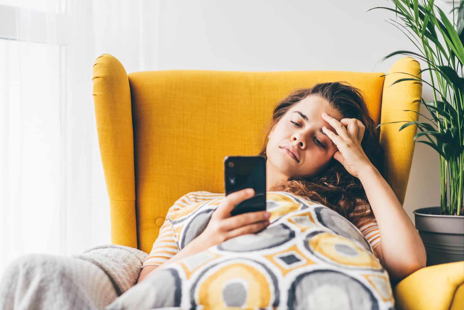 Frustrated woman reading message in a smartphone