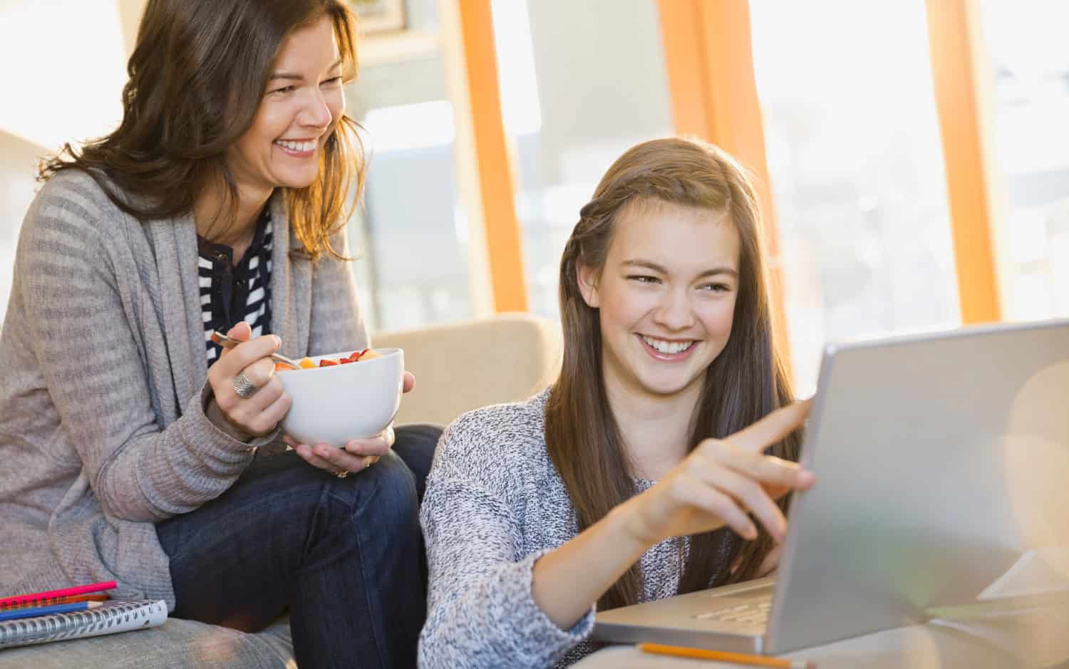 Mother And Daughter Using Laptop In Living Room