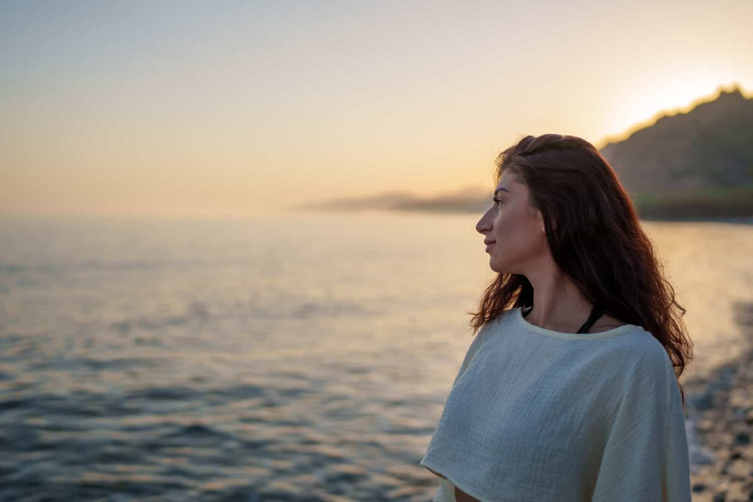 Side view of a woman admiring a beautiful sunset. concept of inner peace and happiness