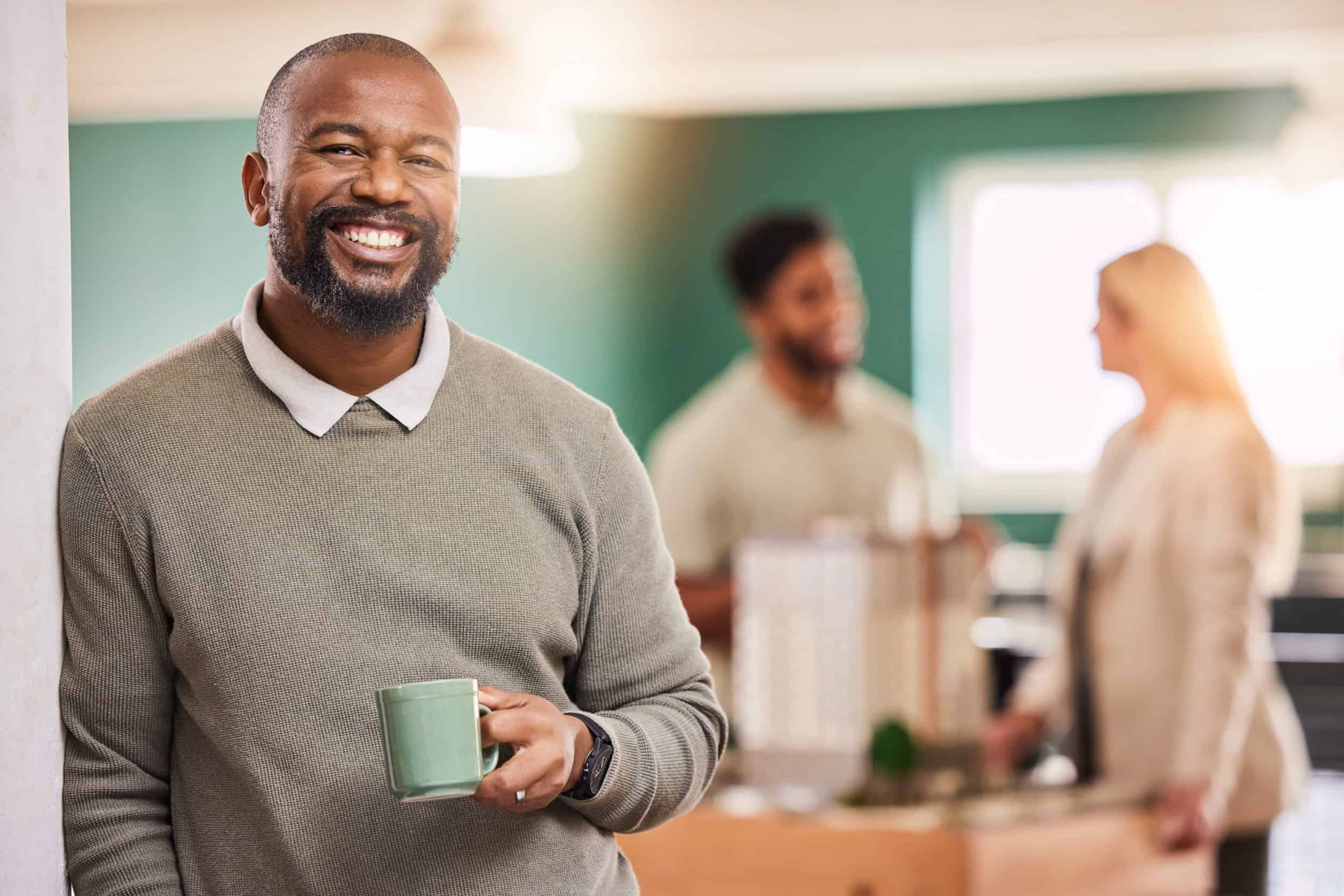 black man, smiling while holding a cup of coffee, concept of recovery and successful detox program