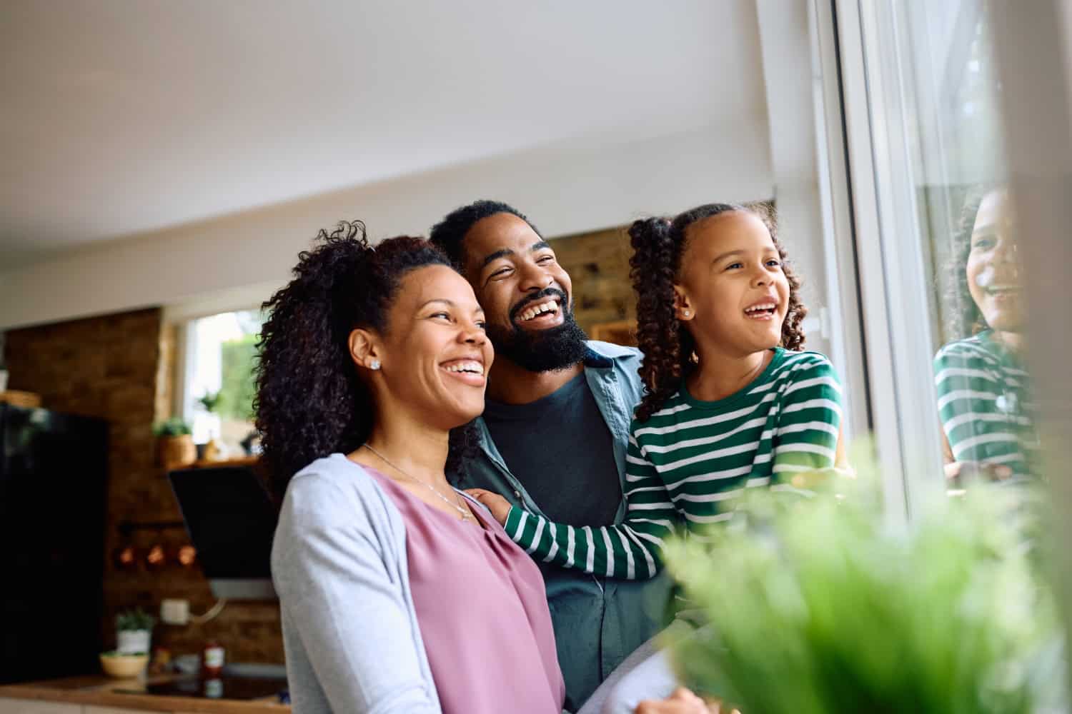 family having a joyful moment at home, father, mother and young daughter smiling together