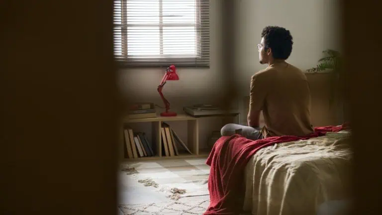 man sitting alone in his bedroom, reflecting on life and recovery