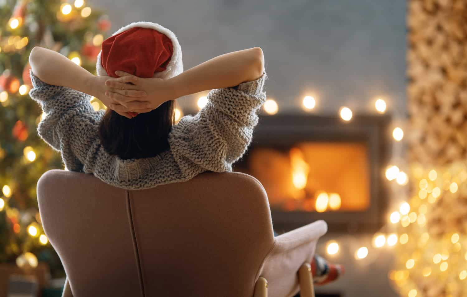 woman is relaxing near christmas tree, concept of calm holiday season