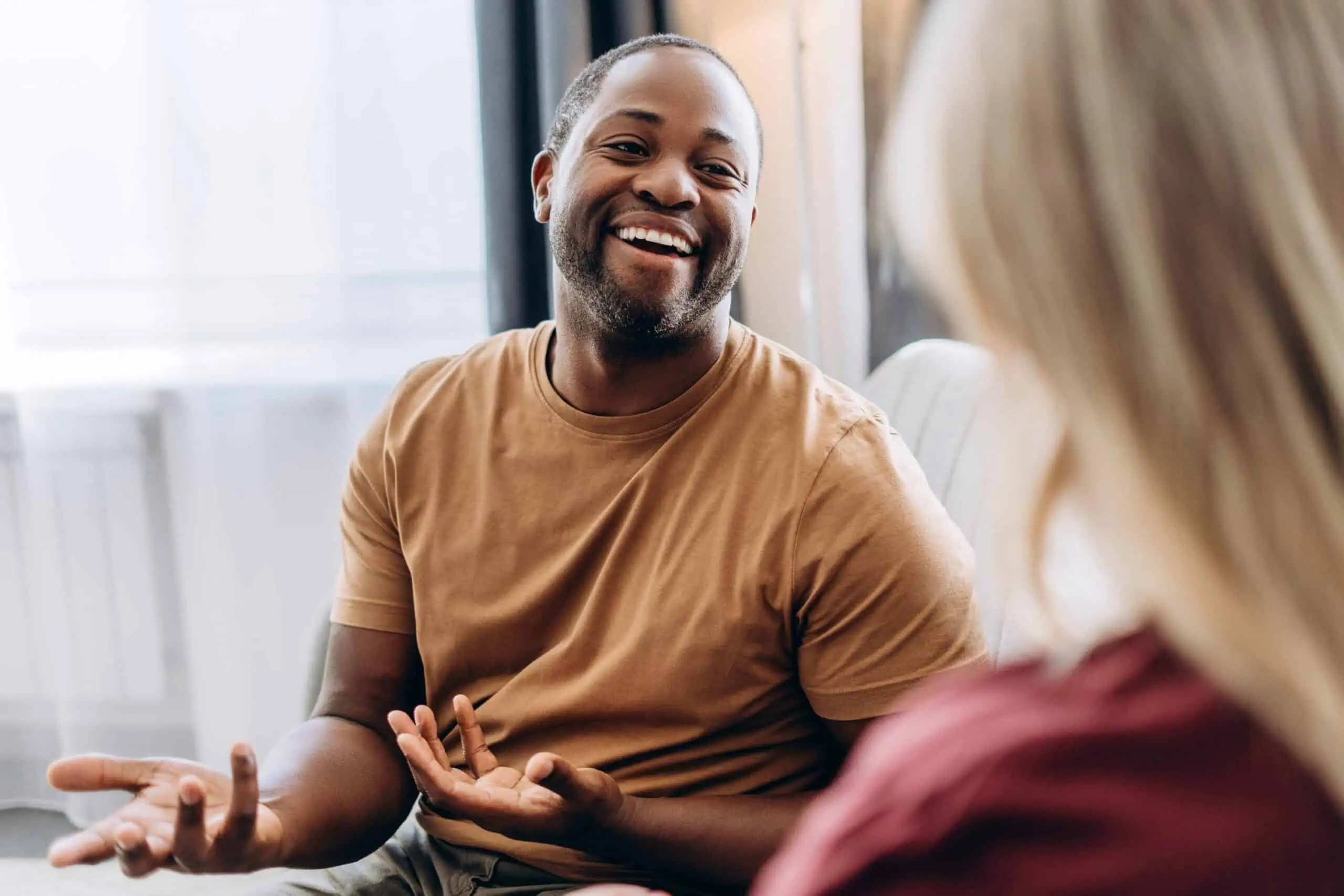 young man smiling while talking to counselor during therapy session